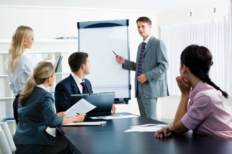 Un homme d'affaire explique quelque chose sur un tableau